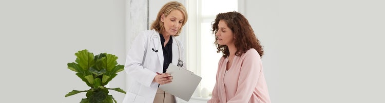 actor portrayal of female doctor reading results to a female patient