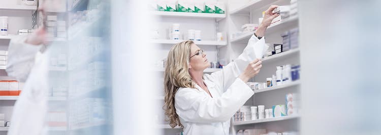 Actor portrayal of pharmacist reaching for a medication