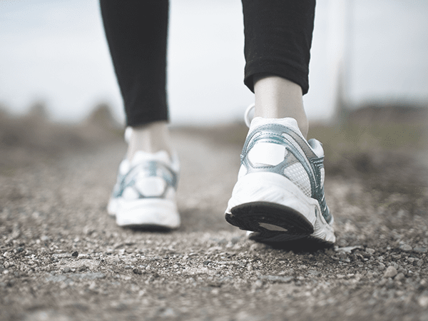 feet walking on dirt path