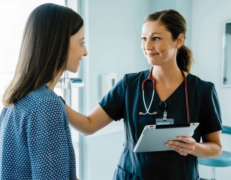 actor portrayal of girl nurse showing results to a female patient